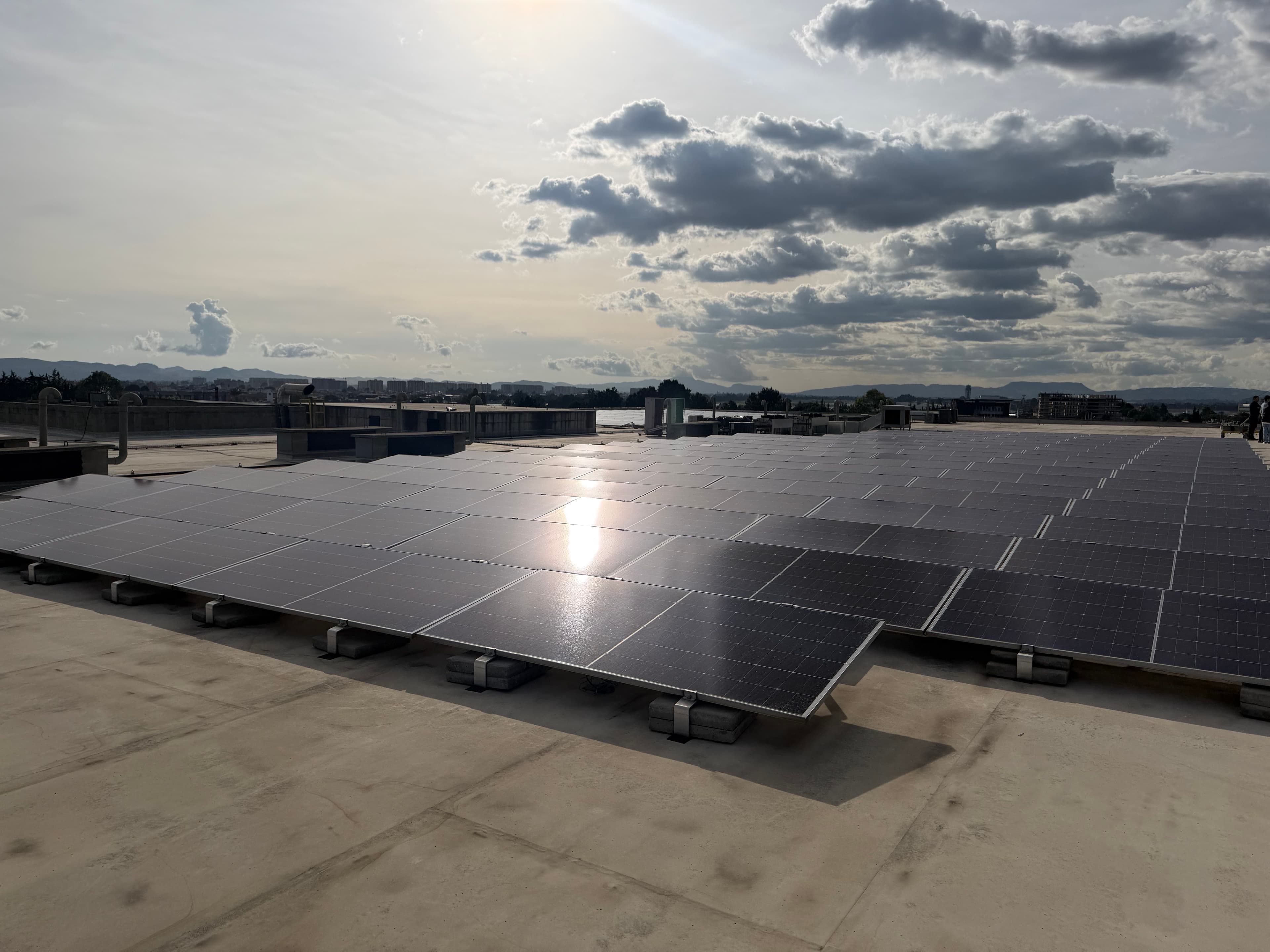 Vista general de paneles solares instalados sobre una cubierta bajo el cielo iluminado