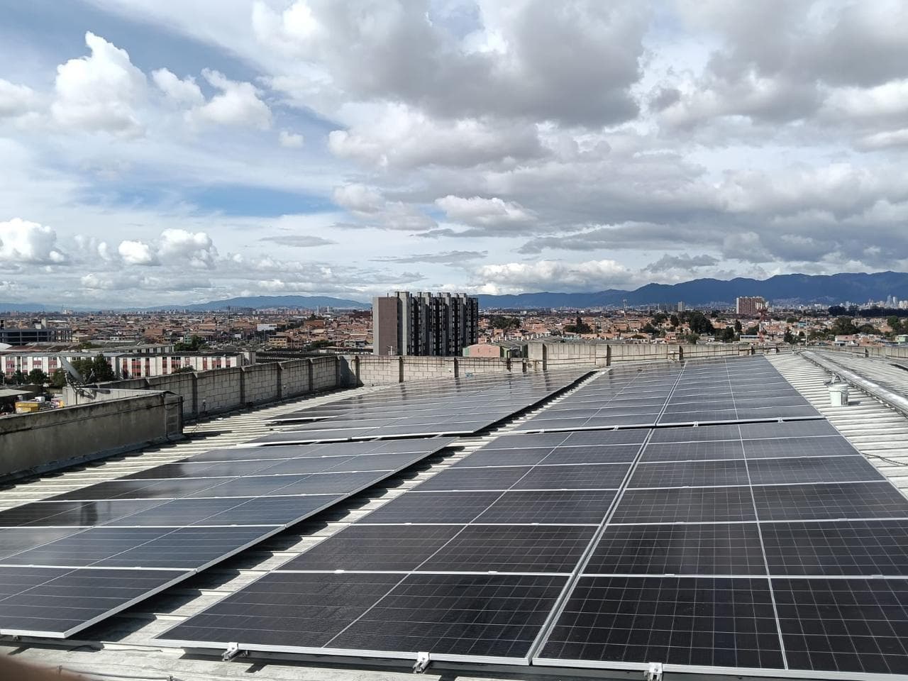 Paneles solares instalados sobre la cubierta de un centro comercial con vista a la ciudad