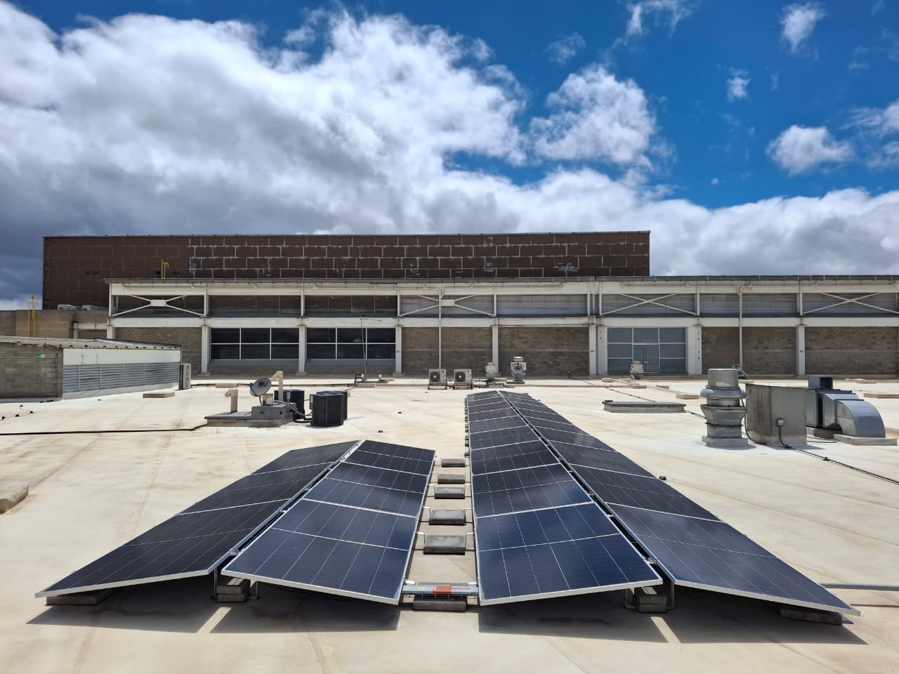 Filas de paneles solares instaladas sobre la cubierta plana de un centro comercial